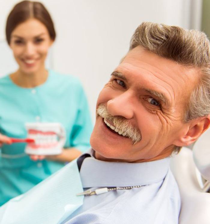 a patient smiling while visiting his dentist