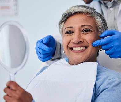 Woman smiling as dentist points at her teeth