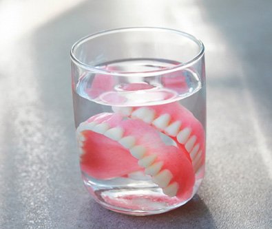 a pair of dentures in a glass of water