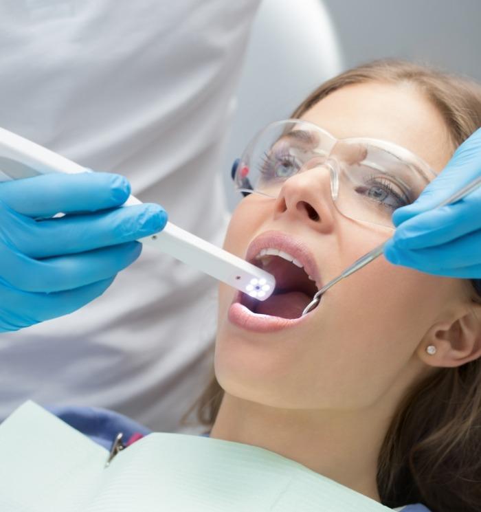 Woman receiving dental exam with intraoral camer