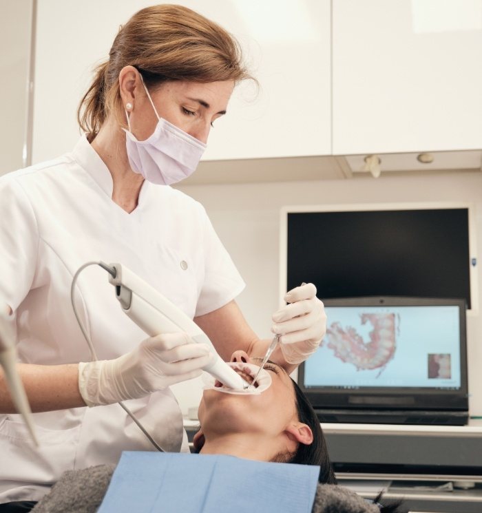 Dental team member taking digital dental impressions of a patient