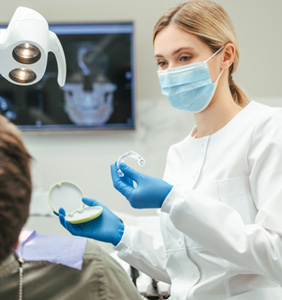 Dentist showing patient clear aligner in treatment room