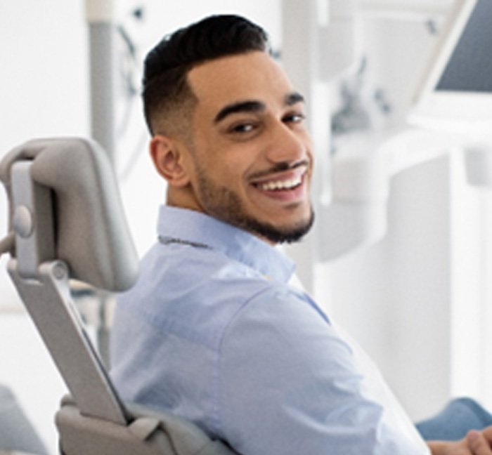Man in light blue shirt smiling in treatment chair