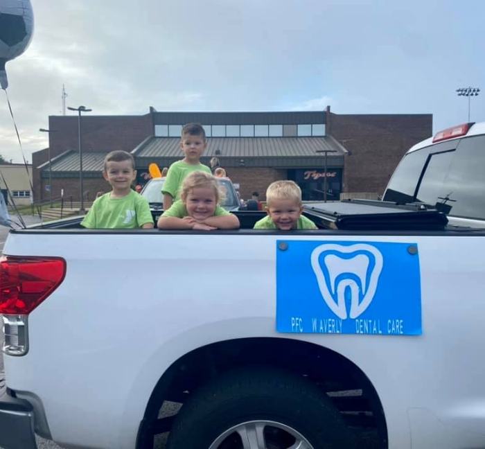 Kids sitting in back of pickup truck for community event