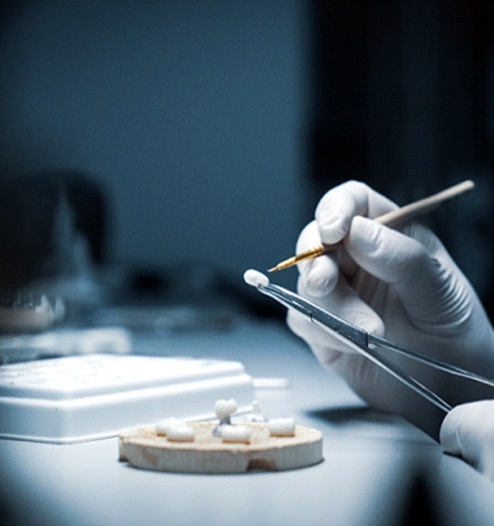 A dental technician glazes a custom dental crown in Waverly, OH