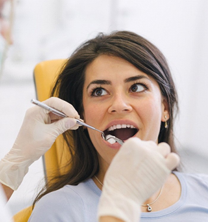 A dentist checking the teeth of their patient after a successful dental crown