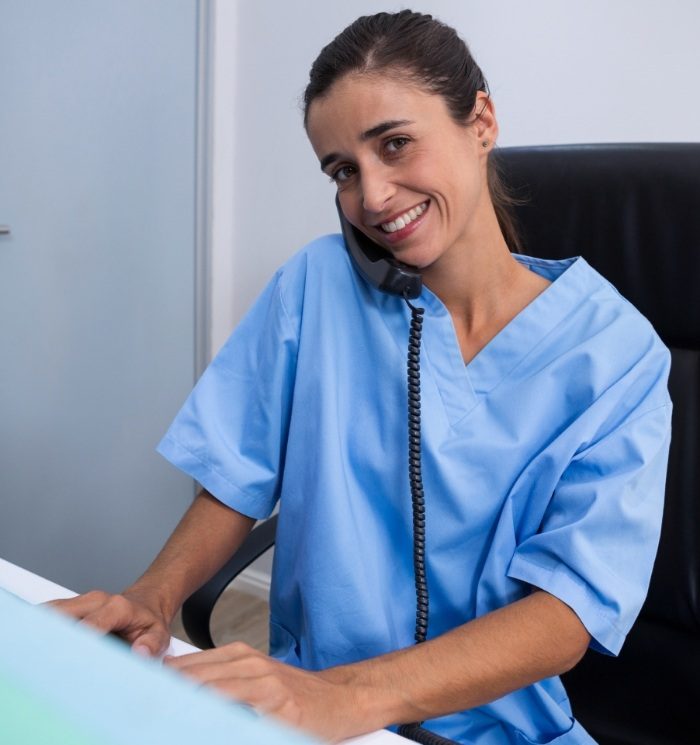 Smiling dental team member talking on phone