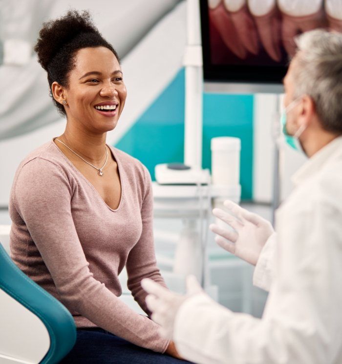 Smiling woman talking to her emergency dentist in Waverly