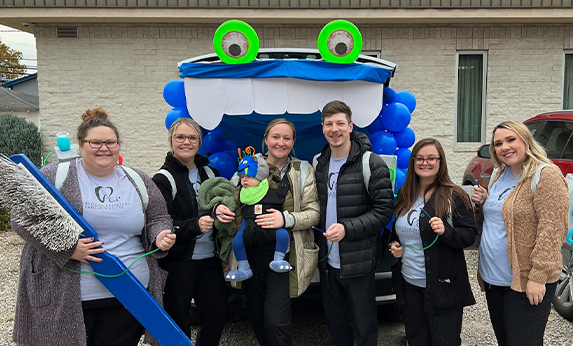 Waverly dental team with giant toothbrush and toys for kids community event