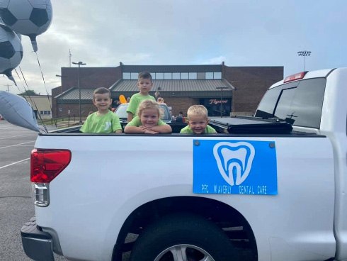 Kids sitting in back of pickup truck