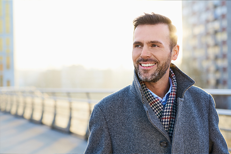 Man in gray peacoat walking around city