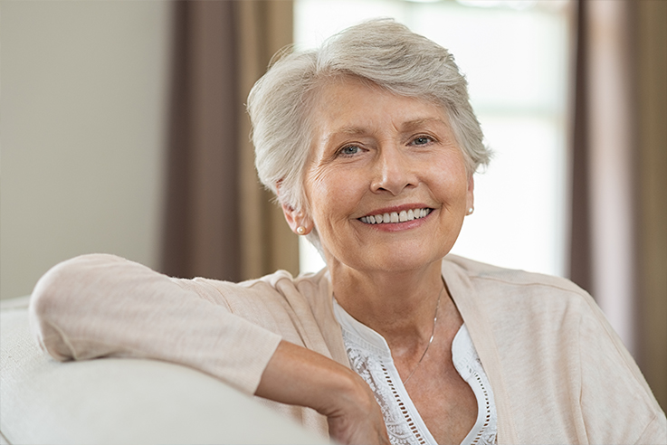 Senior woman leaning over back of couch