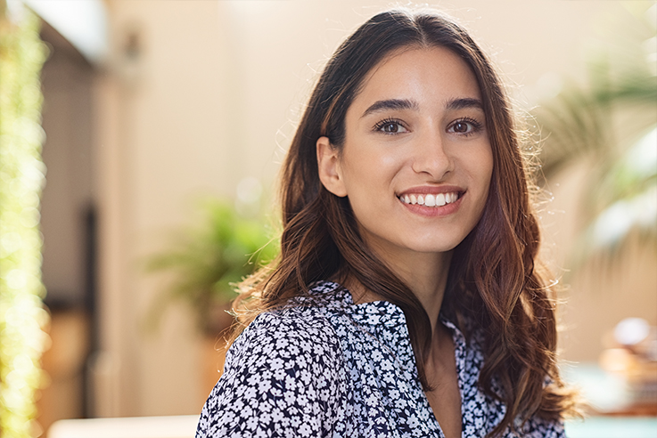 Smiling woman in black and white flowery blouse