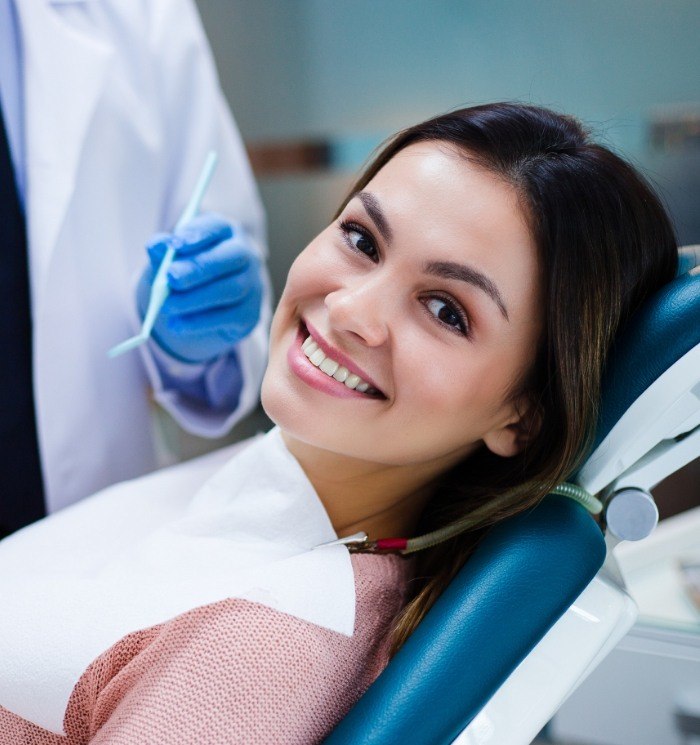 Young woman smiling during dental checkup and teeth cleaning