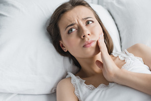 Woman lying in bed with a toothache